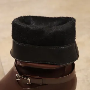 Close-up of warm black faux fur lining and buckle detail on brown ankle boots