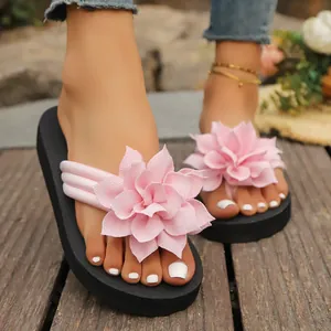 Primer plano de elegantes chanclas de mujer con flores rosas en suelo de madera rústico