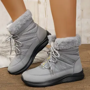 Nahaufnahme grauer Winter-Schneestiefel mit Kunstfellbesatz und gesteppter Nylon-Textur.