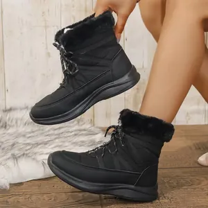 Nahaufnahme schwarzer Wintersneakers mit weichem Kunstfellfutter und dicker Sohle.