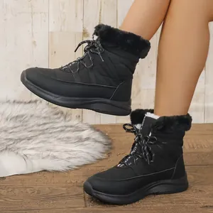Nahaufnahme schwarzer Winterstiefel mit weichem Kunstfellfutter und Schnürdetail