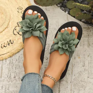 Primer plano del elegante adorno de flor de tela verde en las chanclas de verano para mujer