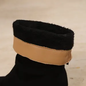 Detail of women's ankle boot featuring thick black faux fur lining and tan leather trim