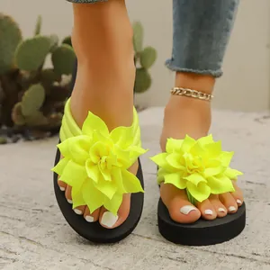 Primer plano de la decoración de flor amarilla en sandalias de dedo de mujer.