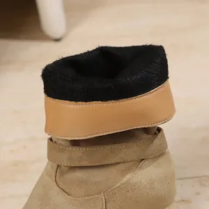 Close-up of black faux fur lining and suede texture of women's warm winter boots