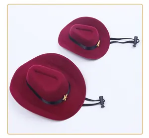 Detail view of two burgundy pet cowboy hats with gold star and adjustable strap
