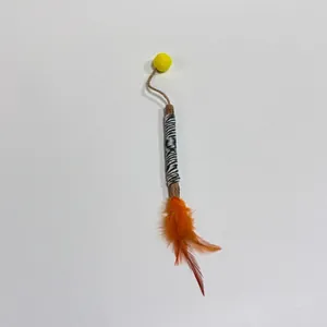 Natural silvervine stick cat toy with orange feathers and yellow pom-pom for teething.