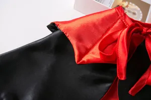 Nahaufnahme eines rot-schwarzen Satin-Halloween-Umhangs für Haustiere mit einer Schleife