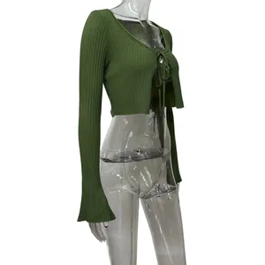Detailed side view of dark green ribbed knit cropped cardigan with flare sleeves and tie-front.