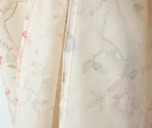 Detailed close-up showing high-quality overlock stitching on floral print dress fabric