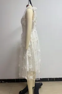 Detailed side view of an elegant white lace tulle dress featuring floral embroidery on a mannequin