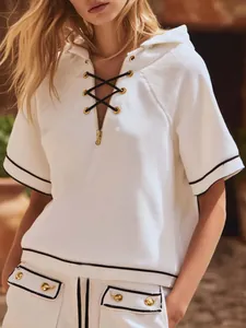 Detail view of white ribbed knit hooded top with black lace-up front detail.