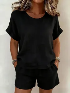 Zweiteiliges Damen-Set mit schwarzem Rundhals-Oberteil und passenden Shorts an einem Modell