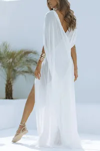 Detailansicht eines weißen, transparenten Strandkleides mit hohem Seitenschlitz