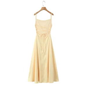 Detailed view of the elegant lace-up backless design on a light yellow summer dress