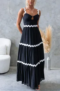 Détail de robe longue noire avec bordures festonnées blanches et jupe à volants évasée