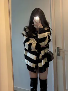 Oversized black and white striped knit cardigan in a casual lifestyle mirror selfie.
