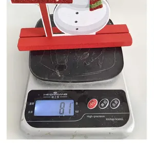 Detailed view of a wooden snowman Christmas table decoration on a scale showing 81g weight