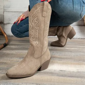 Detailansicht der khakifarbenen bestickten Western-Cowboystiefel auf Holzgrund