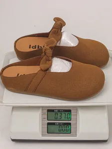 Close-up of brown suede mule sandals weighing 0.37kg on a white digital scale.