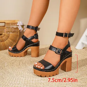 Close-up detail of black chunky heel sandals with a 7.5cm wooden platform and strap
