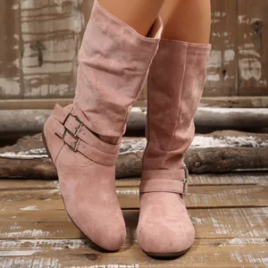 Close-up detail of stylish pink suede slouchy knee-high boots with double buckle straps