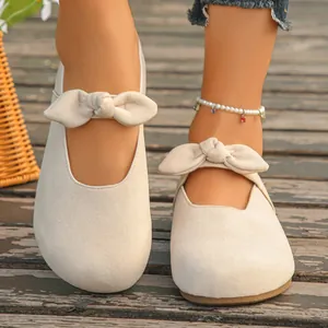 Elegant beige flat mules with bow tie detail for casual summer wear