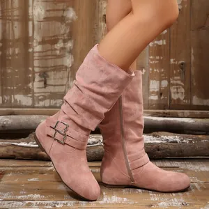 Detailed view of pink suede slouchy mid-calf boots with buckle straps and zipper