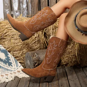 Vista dettagliata di stivali da cowboy occidentali in pelle scamosciata marrone ricamati