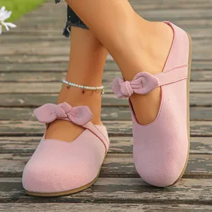 Close-up of pink suede-like Mary Jane mule sandals featuring a decorative bow knot
