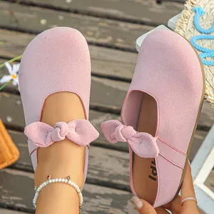 Detail shot of pink suede bow platform clogs showing soft texture and cozy design.