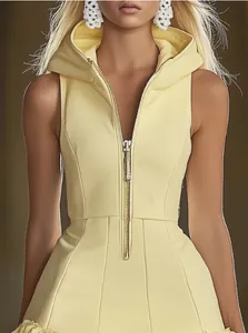 Detail view of a pale yellow sleeveless hooded mini dress with a front zipper bodice