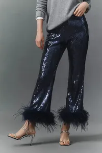 Close-up of elegant navy blue sequined trousers featuring lush faux feather trim at the hems