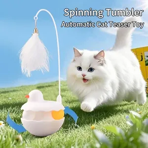 Interactive tumbler cat toy with white feather teaser and bell on green grass
