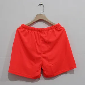 Vista detallada de pantalones cortos deportivos naranja neón para hombre fitness