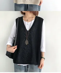Dettaglio del gilet in maglia nera da donna con scollo a V e motivi traforati rétro