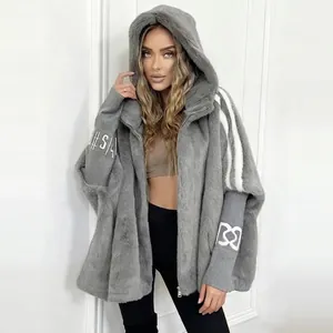 Detail view of women's oversized grey hooded faux fur jacket with sleeve patchwork