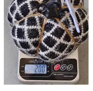 Handmade black and white checkered knitted pumpkin ornament weight detail showing 200g