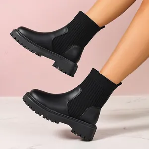 Detalle de botines negros para mujer con suela de plataforma dentada y parte superior de punto