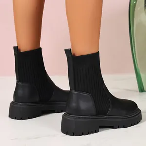 Detalle de los botines negros para mujer con puños de punto y suela de plataforma gruesa.