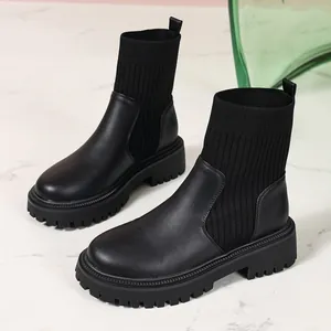Detalle de botines negros con plataforma, parte superior de punto y suela gruesa