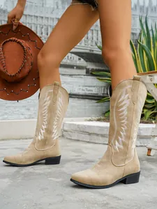 Detailed view of women's tan Western tall boots with white embroidery and pointed toe