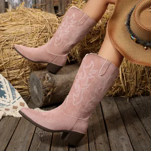 Dettaglio di stivali da cowboy rosa ricamati in pelle scamosciata con tacco largo e scollo a V.