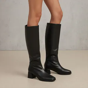 Side view of elegant black knee-high knight boots with square toe and chunky heel design