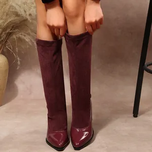 Detailed view of burgundy pointed toe boots featuring suede and patent leather materials