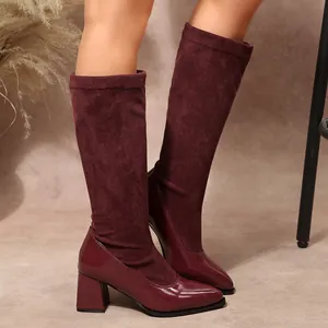 Detail shot of burgundy vintage patchwork boots with glossy toe and suede upper.
