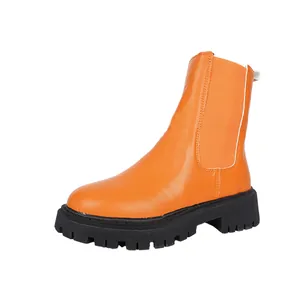 Vue latérale d'une bottine Chelsea orange vif avec une semelle crantée noire épaisse