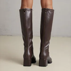 Detailed back view of brown knee-high boots featuring block heels and full zippers