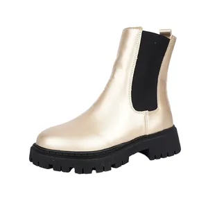 Bottines Chelsea dorées métallisées avec semelle noire épaisse et panneau élastique.