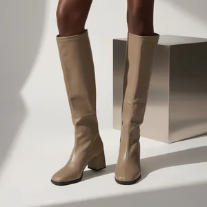 Detail shot of stylish beige square toe knee high boots with comfortable chunky heels